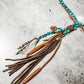 Necklace with turquoise beads and leather tassels.