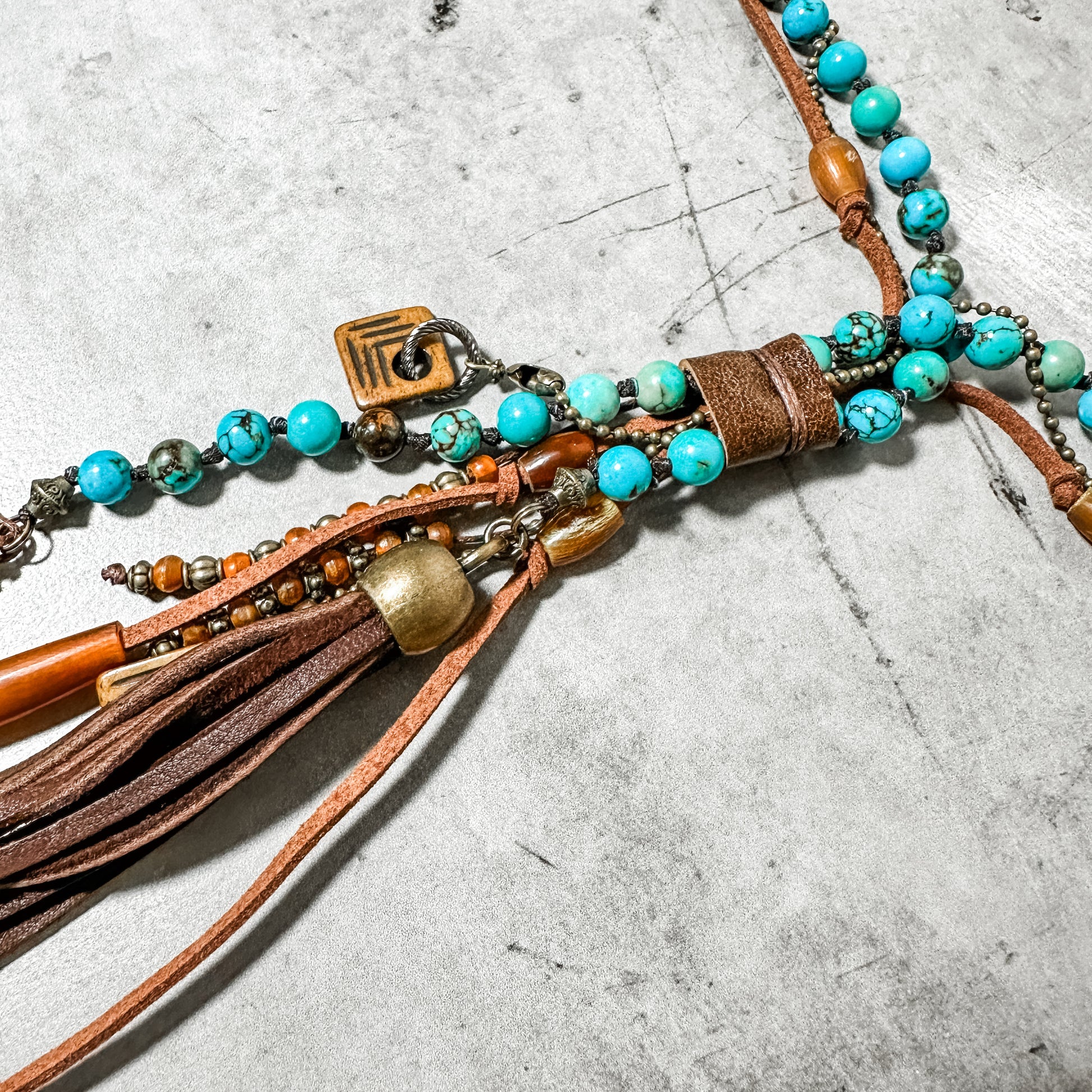 Turquoise beaded necklace with leather accents.