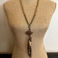 Beaded necklace with pendant on mannequin.