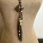 Necklace with a decorative pendant and beads on a mannequin.