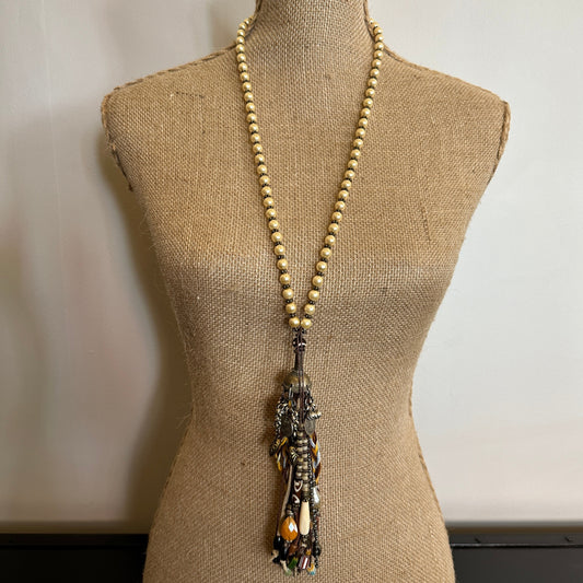 Beaded necklace with tassel on a mannequin.