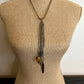 Necklace with charms on a mannequin.