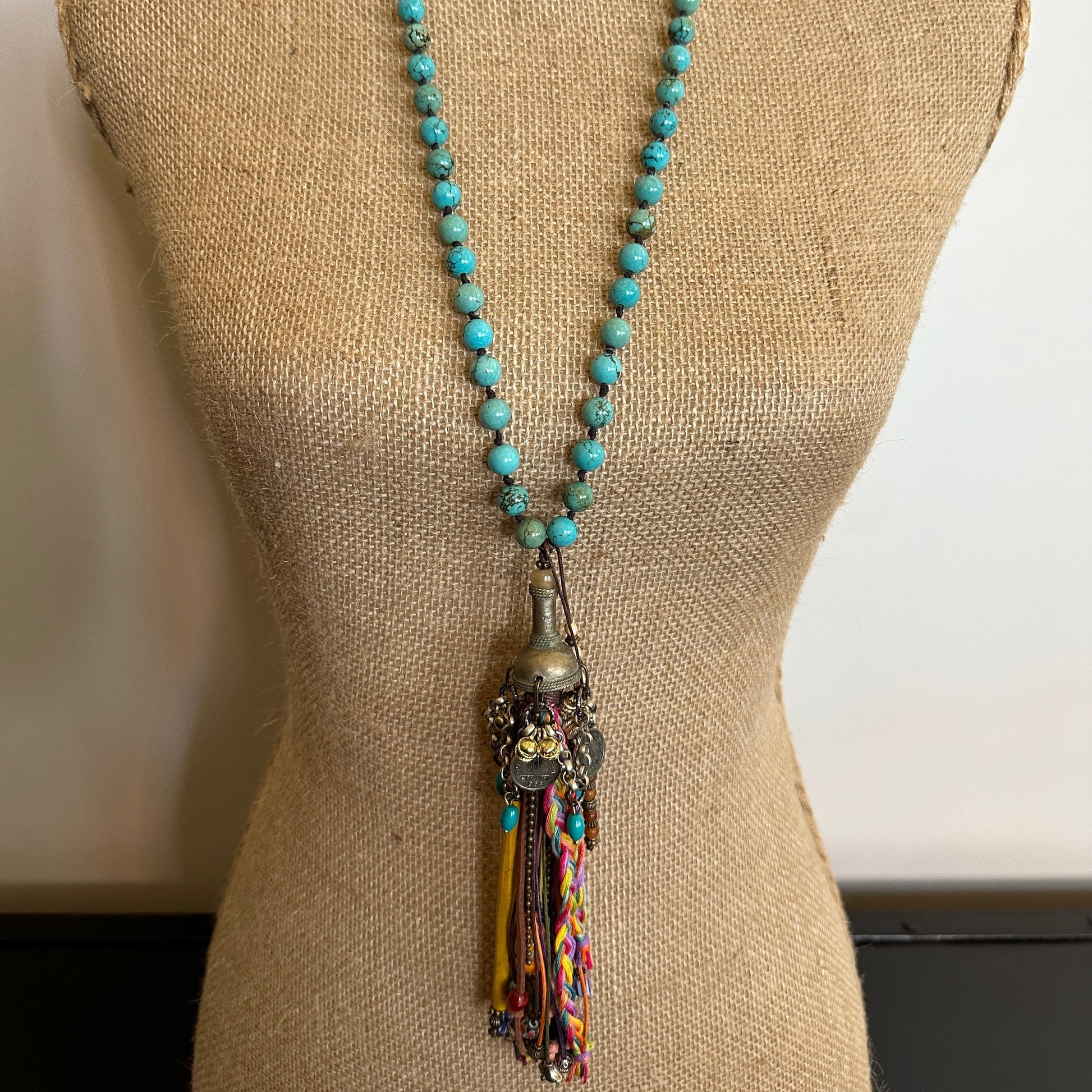 Turquoise beaded necklace with tassel detail on mannequin