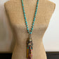 Turquoise beaded necklace with tassel on mannequin