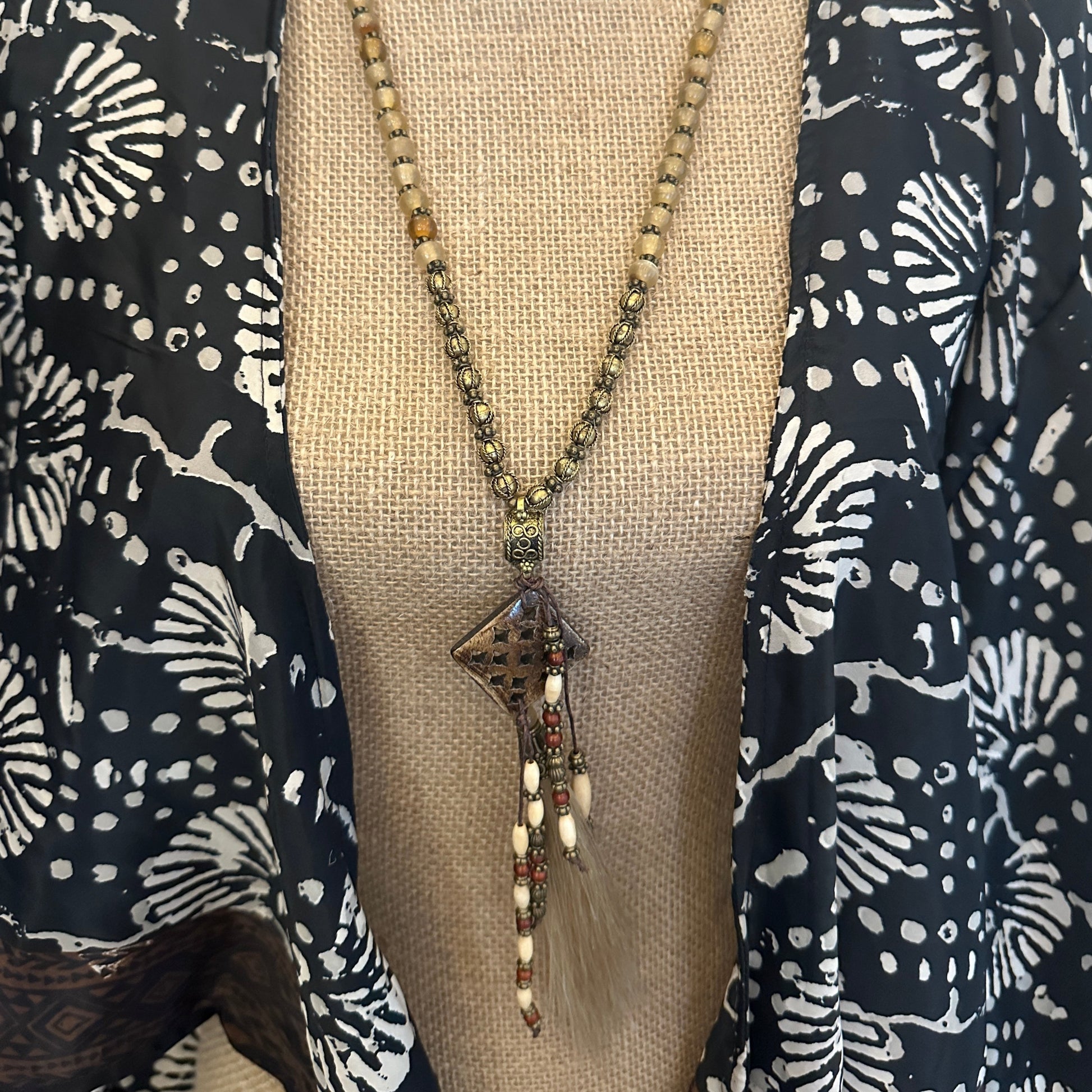 Beaded necklace on patterned fabric.