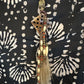Necklace with geometric pendant and tassel.