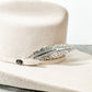 Tan cowboy hat with feather pin.