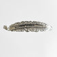Silver feather-shaped hair clip with Bourbon Cowgirl text.