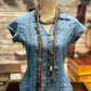 Blue denim shirt on a mannequin with layered necklace.