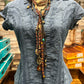 Blue denim shirt with jewelry on a mannequin.