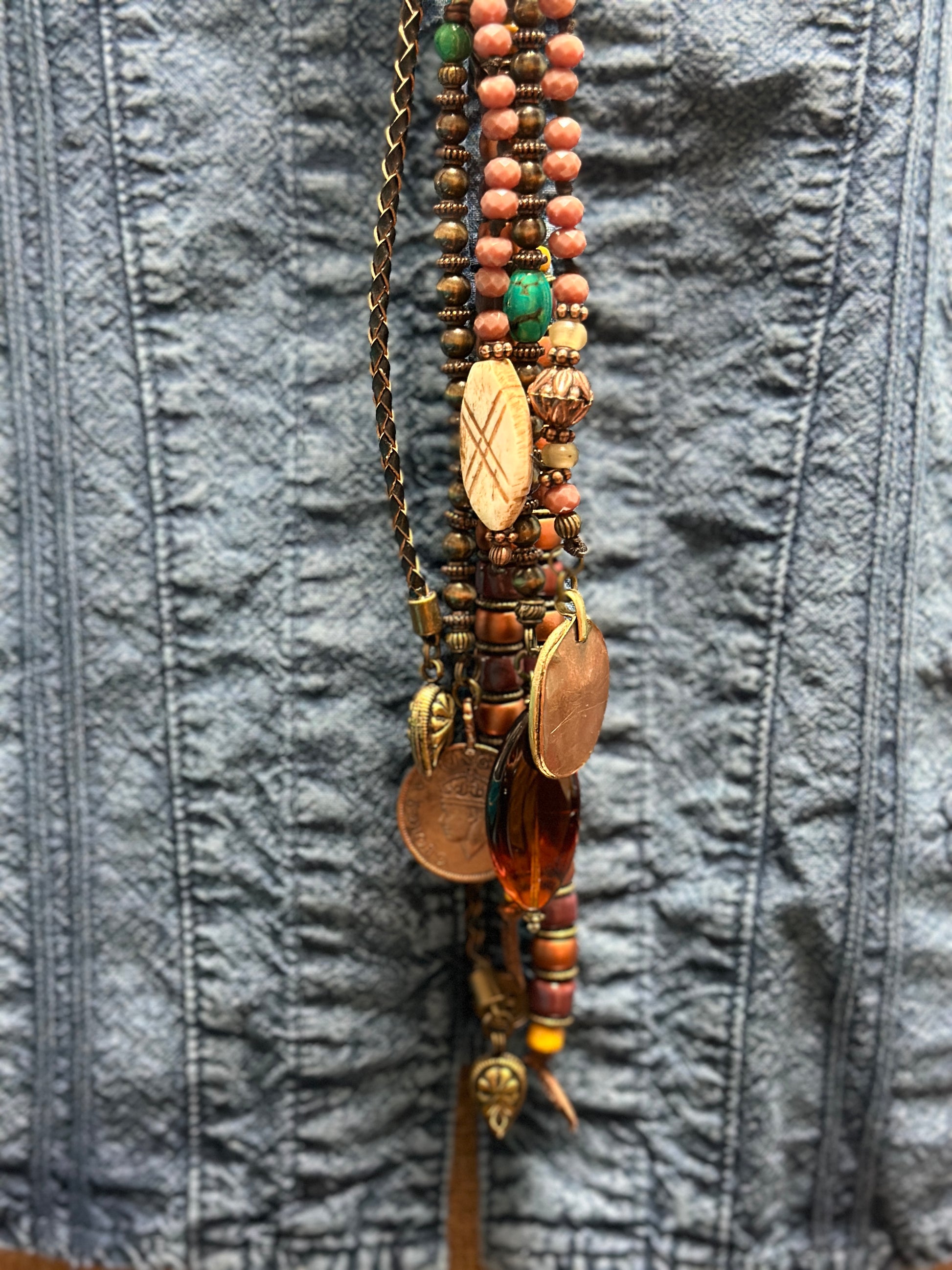 Beaded necklace on blue denim shirt.
