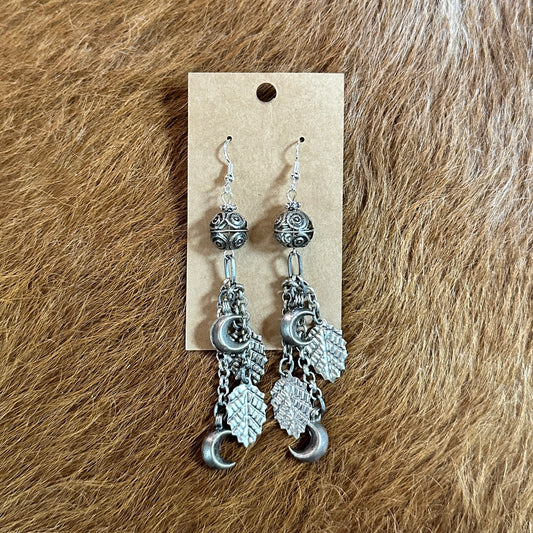 Silver earrings with beads, leaves, and crescent moons.