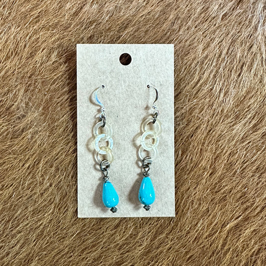 Earrings with turquoise teardrops on display card.