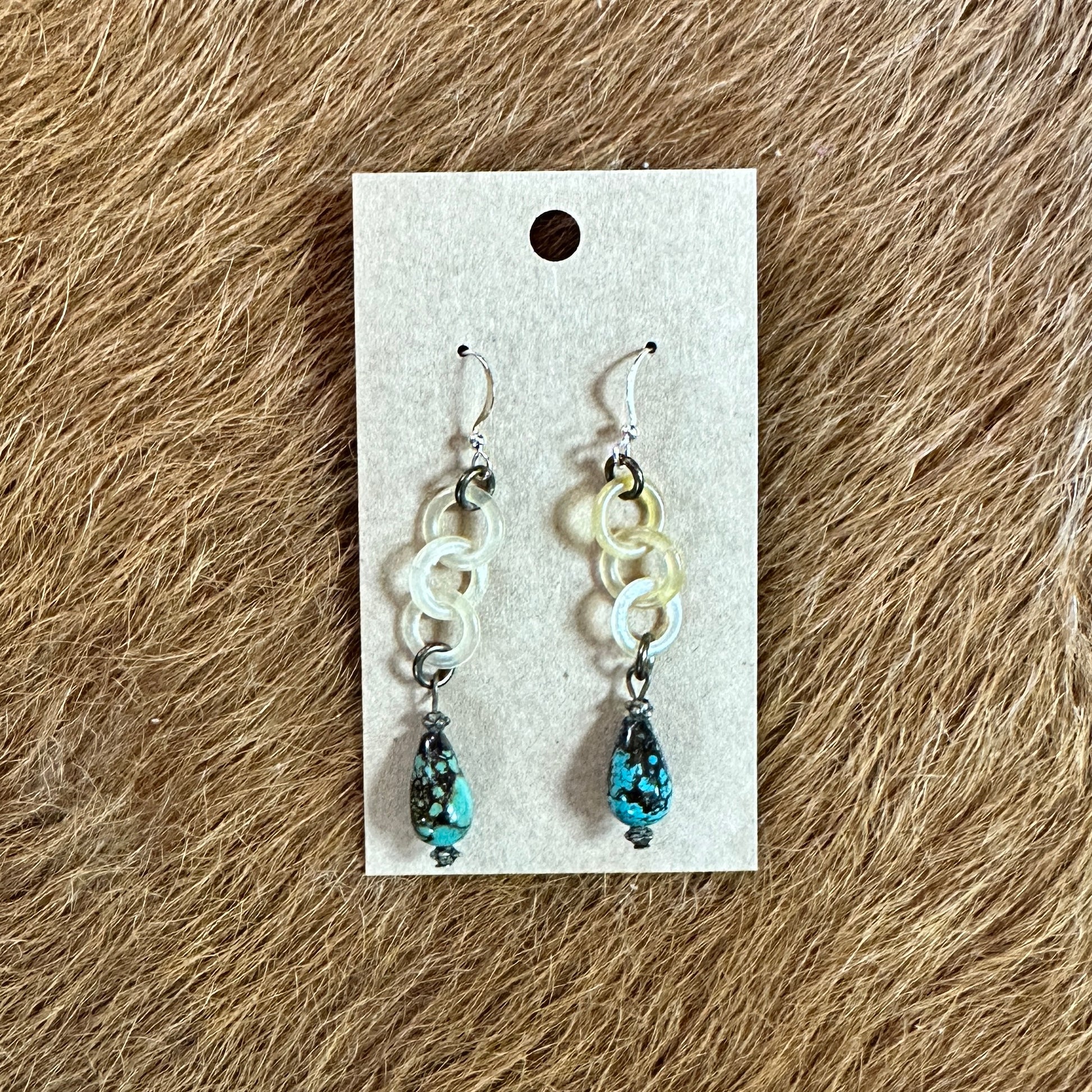 Earrings with turquoise beads on a display card.