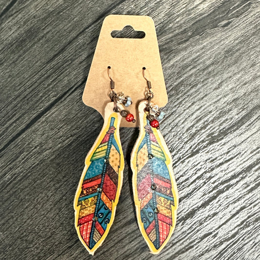Feather-shaped earrings on a cardboard tag.