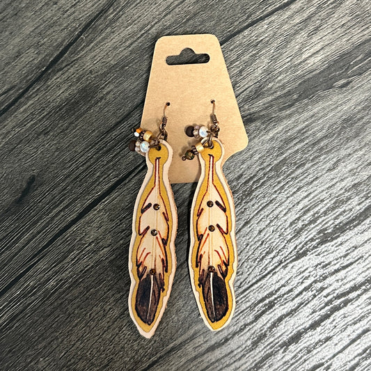 Feather-shaped earrings on a cardboard display card.