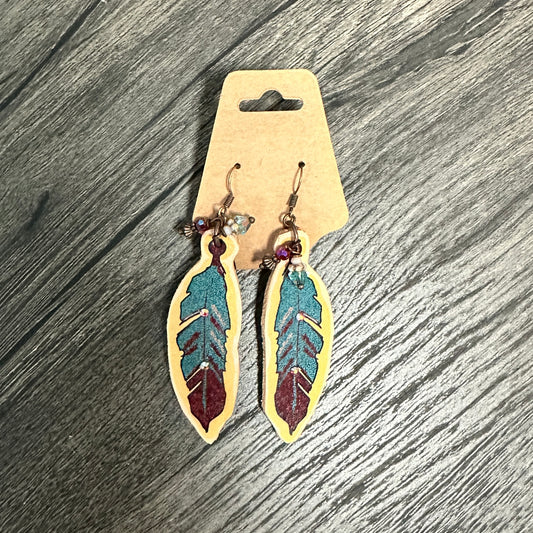 Feather-shaped earrings with painted blue and red design.