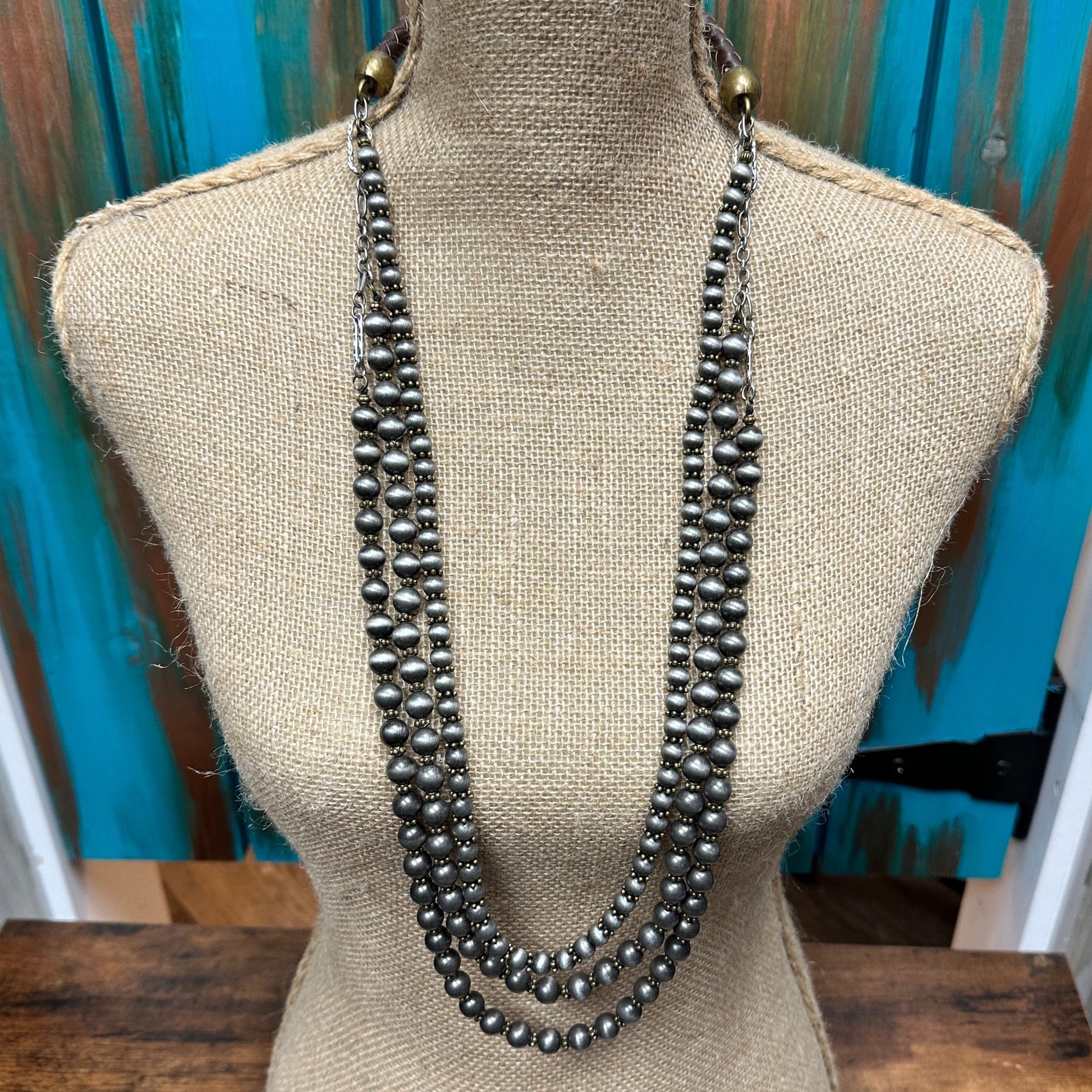 Three-strand beaded necklace on a mannequin.