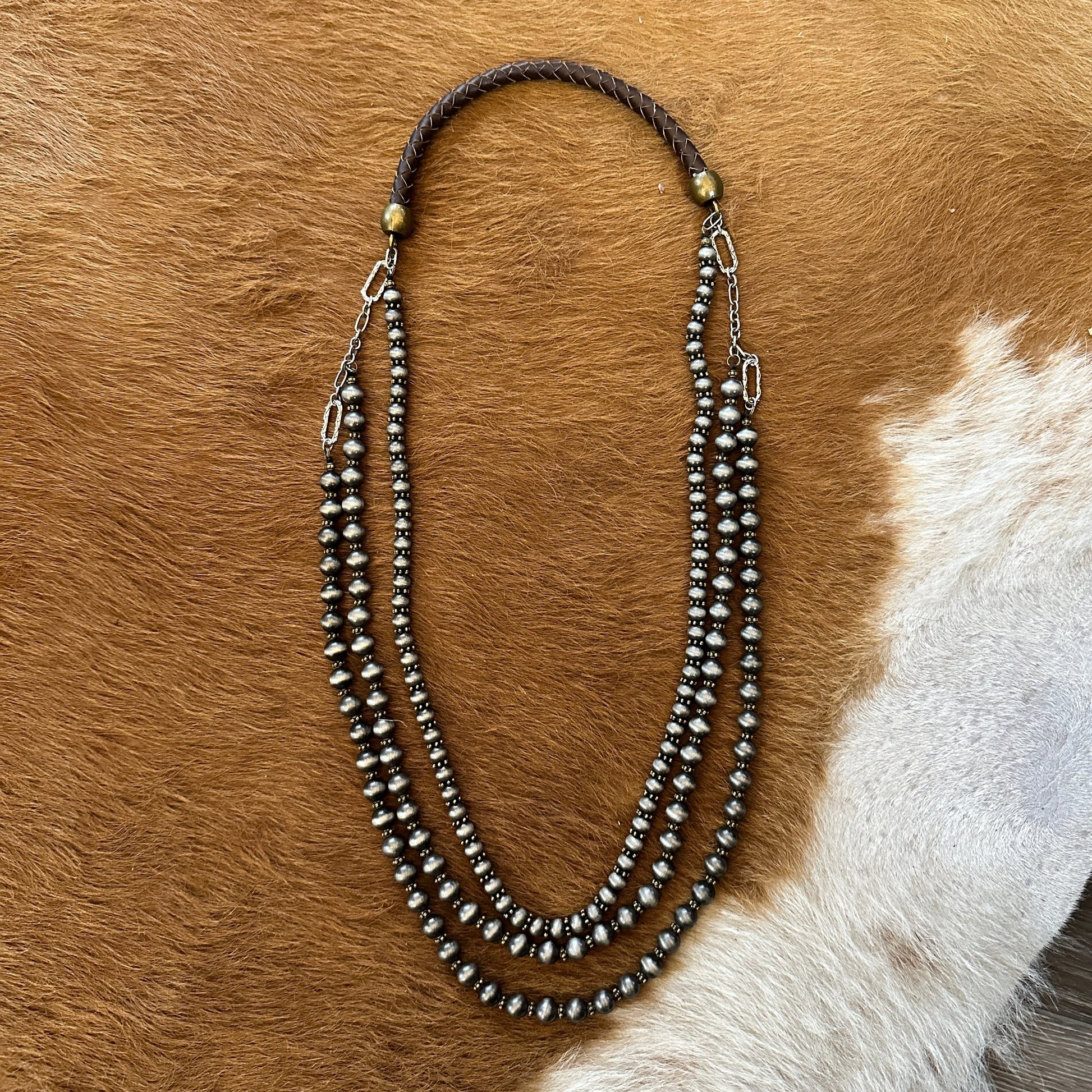Three-strand beaded necklace on brown fur.