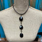 Black stone pendant necklace on a mannequin.
