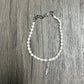 Pearl bracelet with silver charm.