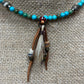 Necklace with turquoise beads and leather pendant.