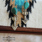 Turquoise arrow earrings on patterned fabric