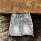 Denim mini skirt with floral embroidery.