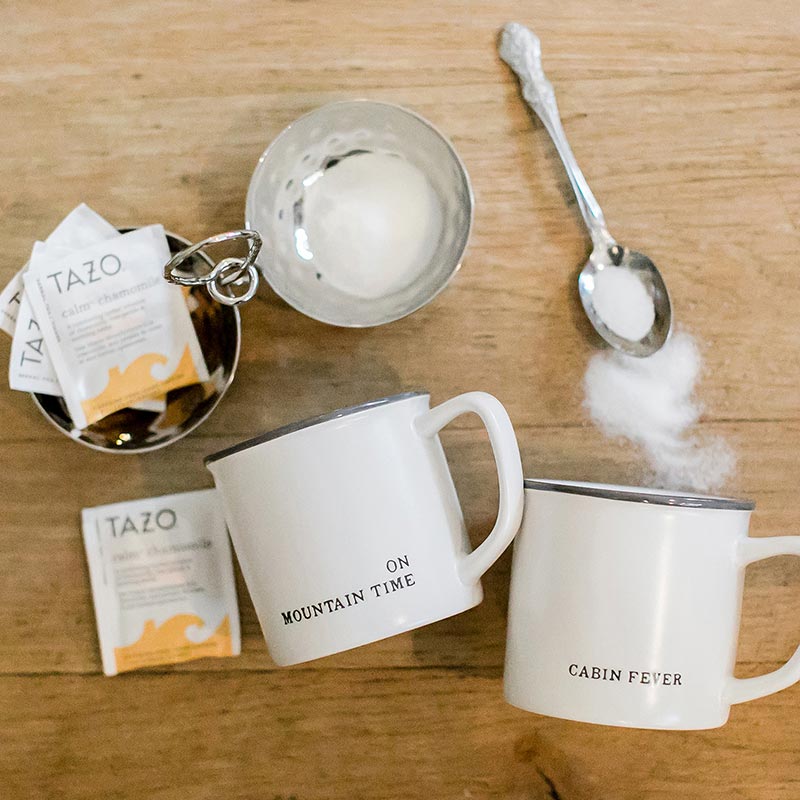 Cozy mugs with tea and mountain time theme
