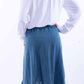 Woman in off-the-shoulder top and denim skirt.