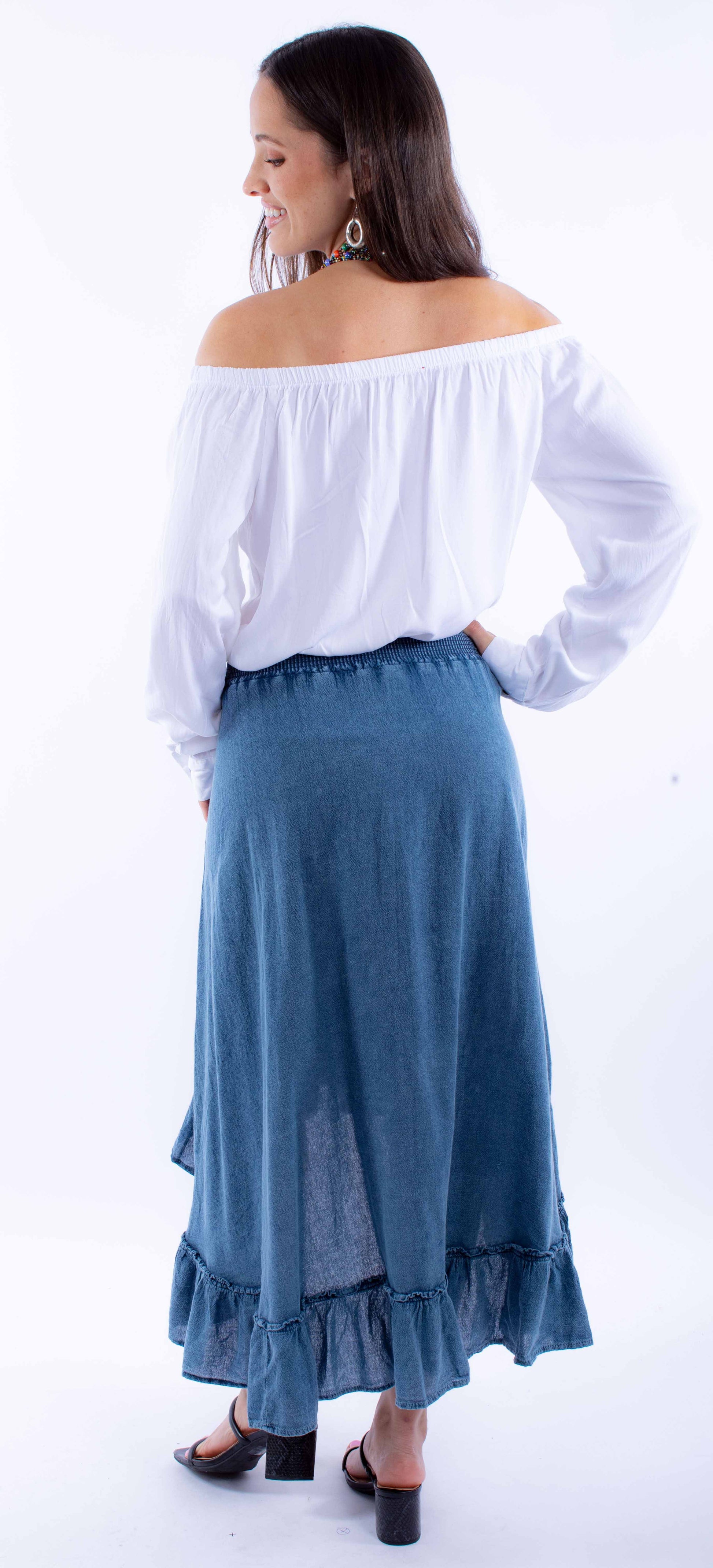 Woman in off-the-shoulder top and denim skirt.
