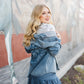Smiling blonde in denim outfit, mural background