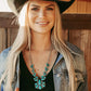 Woman in cowboy hat, Stagecoach necklace