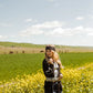 Woman in field of yellow wildflowers, Western style.