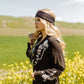Woman in black shirt, WESTERNWILDFLOWER, in field of yellow flowers.