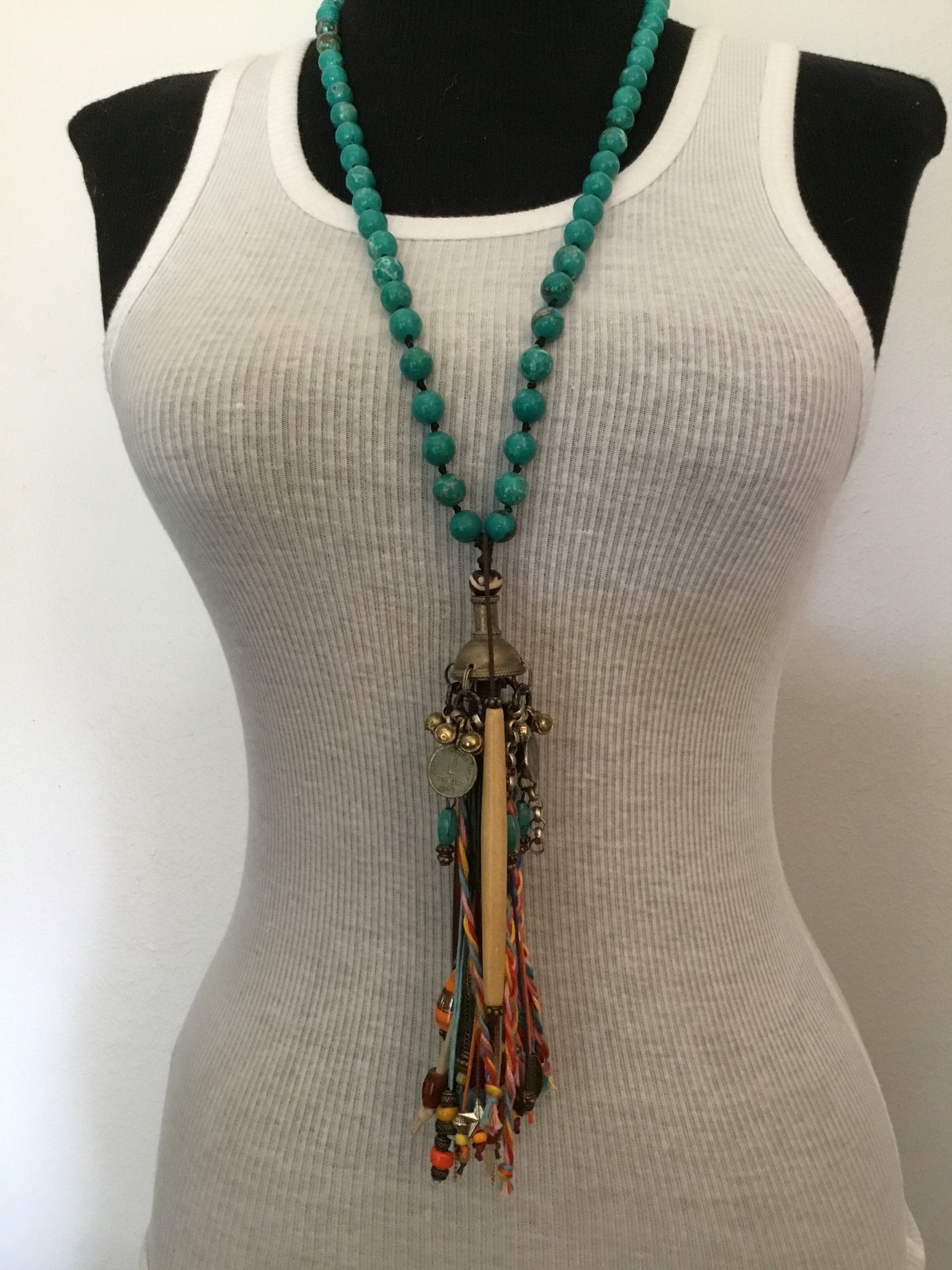 Turquoise beaded necklace on white tank top