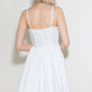 Woman wearing a white sundress, viewed from the back.