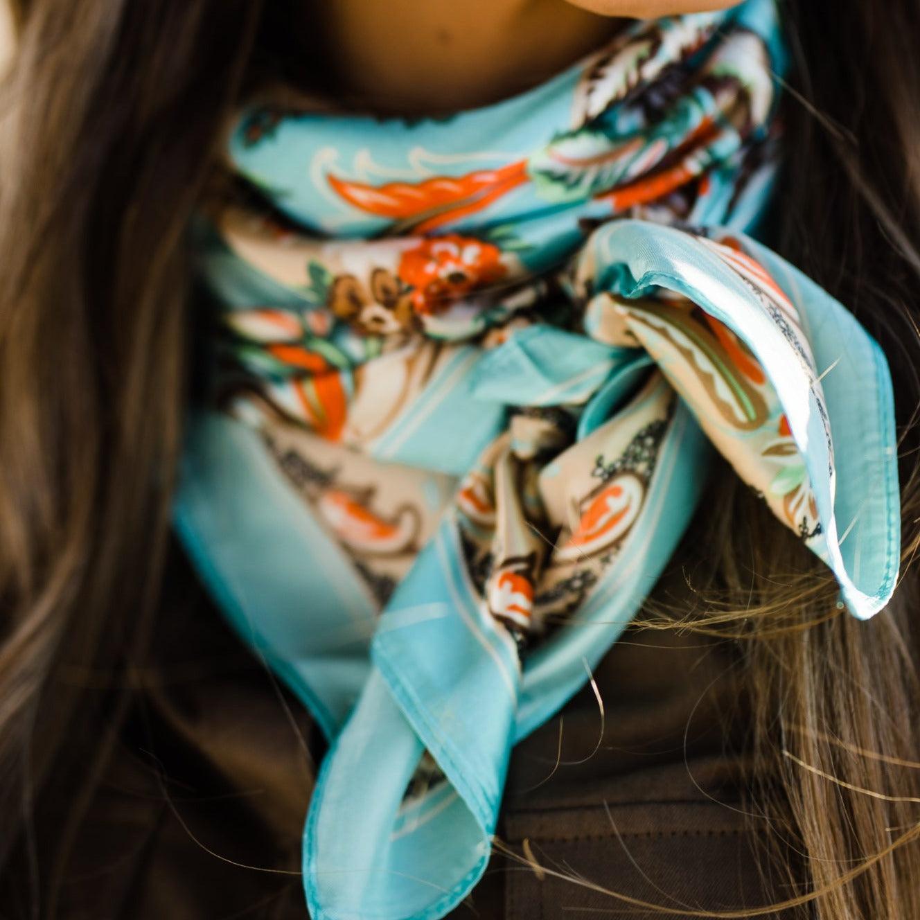 Woman wearing a blue patterned neck scarf.