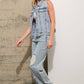 Woman wearing denim vest and jeans.