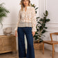 Woman in lace top and jeans.