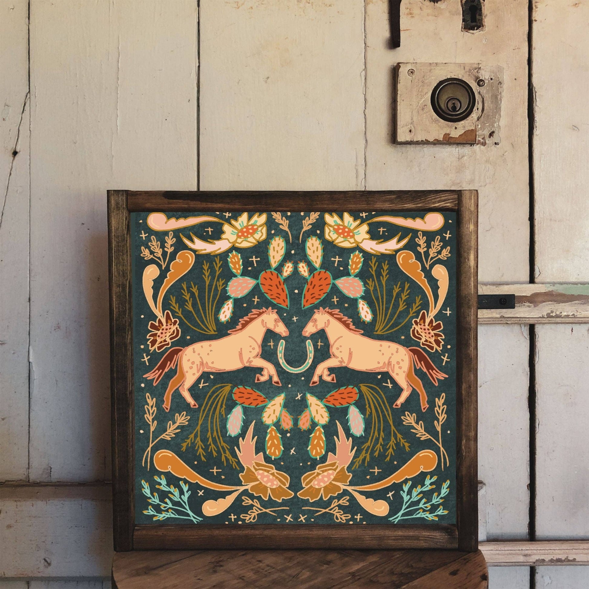 Framed artwork with two horses and floral design.