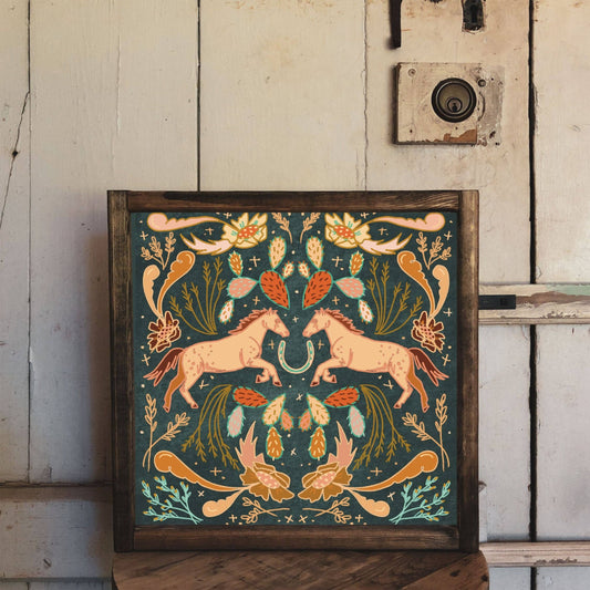 Framed artwork with two horses and floral design.