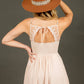 Woman in a dress and hat, back to camera.