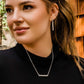 Woman wearing silver bar necklace & earrings