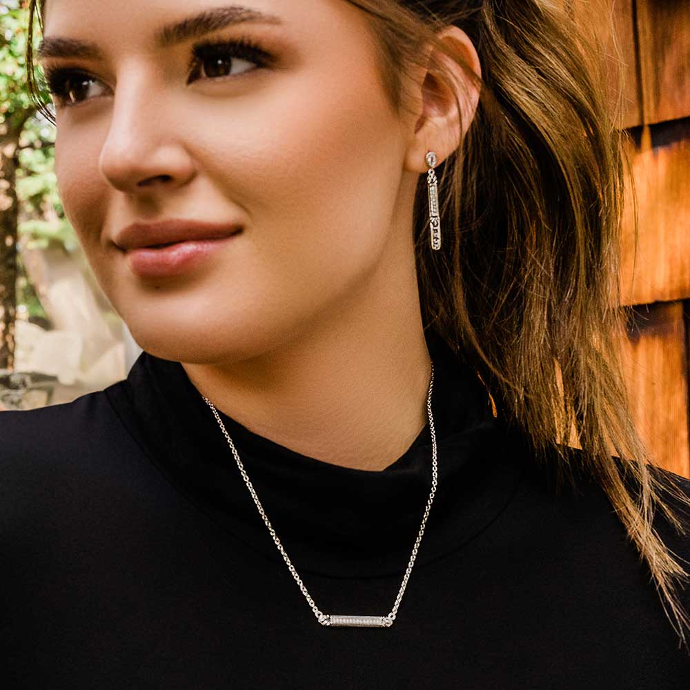 Woman wearing silver bar necklace & earrings
