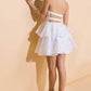 Woman in white strapless dress and heels.