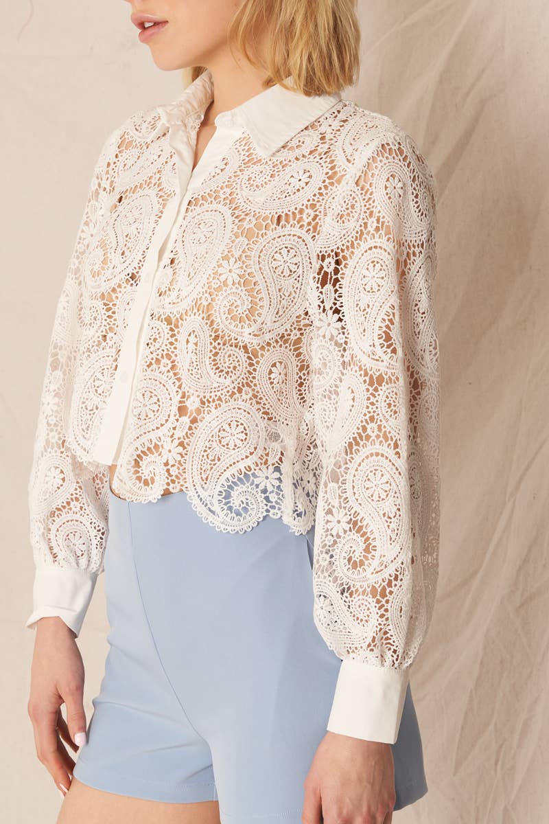 Woman in white lace shirt and blue shorts.