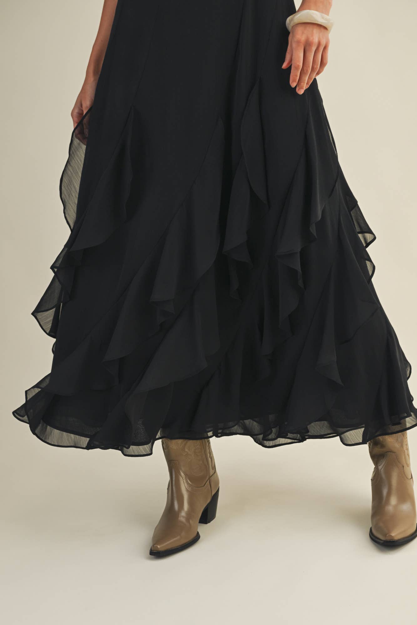 Woman in black ruffled skirt and boots.