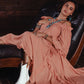 Boho lifestyle image featuring a woman in a pink dress and white boots.