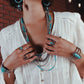 Woman wearing turquoise jewelry and white shirt, lifestyle image